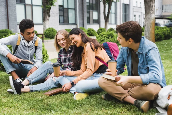 Students sitting on a college lawn.